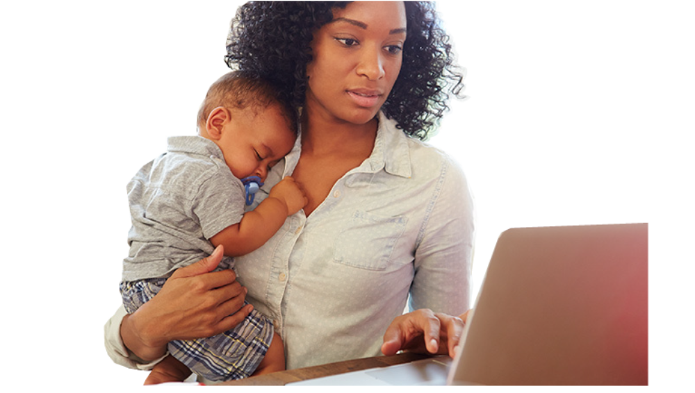 Mom looking at computer screen while carrying her young infant